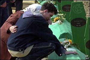 Ramo Smajic, a Bosnian Muslim refugee from Srebrenica, prays at his father's coffin