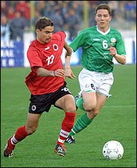 Albania's Ervin Skela is tracked by Ireland midfielder Matt Holland