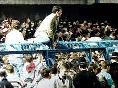 Fans trying to clamber over the crowd control barriers