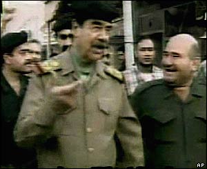 Iraqi TV shows Saddam Hussein in a Baghdad street with supporters and bodyguards
