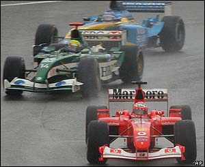 Ferrari's Michael Schumacher is chased by Mark Webber of Jaguar and Renault driver Fernando Alonso