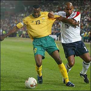 South African captain Lucas Radebe holds off England's Trevor Sinclair 