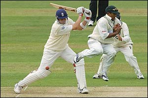 England's Ashley Giles square cuts the ball as a Zimbabwe fielder jumps out of the way