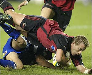 Justin Marshall is tackled by the Auckland Blues defence