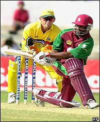 Brian Lara of the West Indies bats as Australia's wicket keeper Adam Gilchrist looks on 
