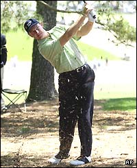 Ernie Els hits a ball out from under a tree during his third round