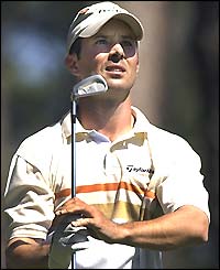 Mike Weir holds his club and watches the ball in the air as he continues to lead in the third round
