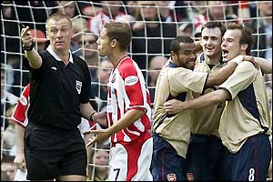 Sheff Utd's Michael Brown argues with referee Graham Poll as Arsenal celebrate take the lead