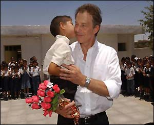 The prime minister gets a kiss from a young Iraqi