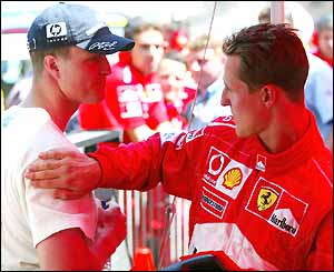 Michael Schumacher congratulates brother Ralf on his pole position