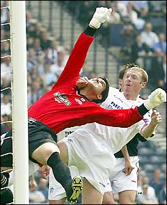 Dundee keeper Julian Speroni punches the ball away from Craig Moore