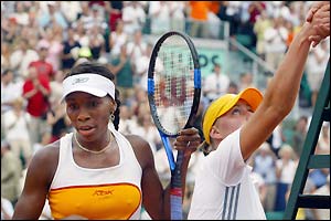 Venus Williams rues defeat while Vera Zvonareva shakes hands with the umpire
