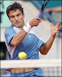 Robredo slams a forehand against Gustavo Kuerten