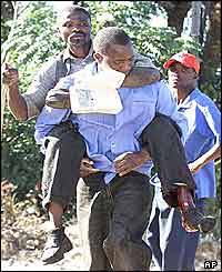 Leonard Chigwagwi is carried by a colleague after being shot in the leg