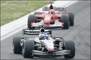 McLaren's Kimi Raikkonen gets the better of Rubens Barrichello