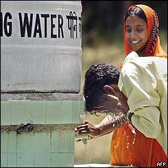 A man splashes water from a tank to cool his face from the heat while he visits Delhi zoo