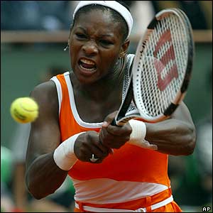 Serena Williams backhands to Justine Henin-Hardenne
