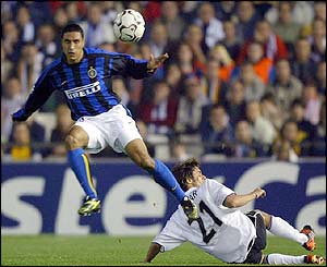 Inter Milan's Ivan Cordoba jumps over Valencia's Pablo Aimar 