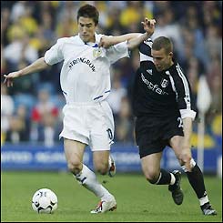 Harry Kewell pushes past Sean Davis