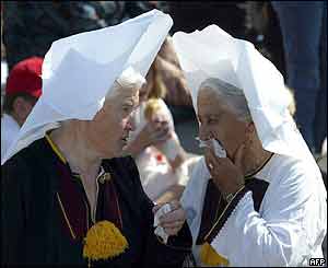 Two Croatian women in traditional dresses chat as they wait for the arrival of the pope