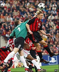 Ajax keeper Bogdan Lobont fights off the Milan attack