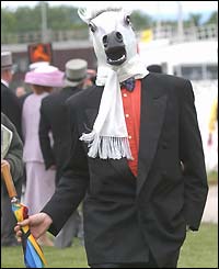 A man dressed as a horse waits for the start of Derby day action 