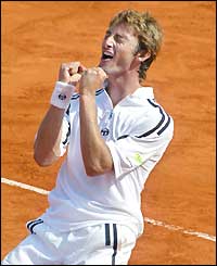 Juan Carlos Ferrero clenchs his fists and sinks to his knees after winning the French Open