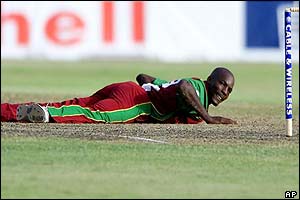 West Indian bowler Vasbert Drakes watches a shot blasted back past him