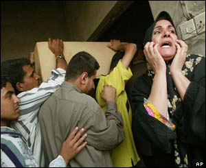 Men carry a coffin as a woman weeps