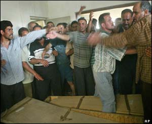 Family and neighbours mourn over the coffins of the Sabirn family members who died in the explosion