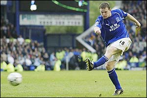 Wayne Rooney hammers the ball towards goal and scores Everton's winner