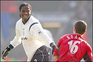 Bolton's Bernard Mendy helps Manchester United's Roy Keane to his feet