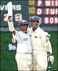 Sri Lankan batsman Hashan Tillakaratne, left, acknowledges the crowd as Kumar Dharmasena, right, hugs him after reaching his century