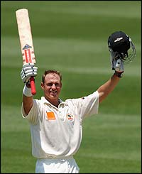 Australia batsman Matthew Hayden raises his bat after scoring a century against England