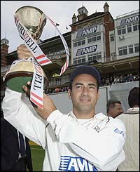 Surrey captain Adam Hollioake holds the 2003 County Championship trophy aloft