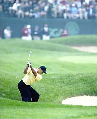 Tiger Woods plays out of the bunker during his level-par opening round at the US Open