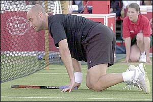 Agassi crouches on the floor after a point