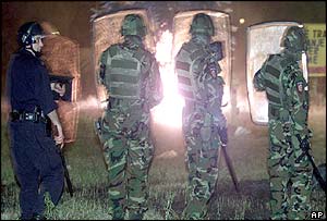 Gendarmerie officers watch burning bins during the riots