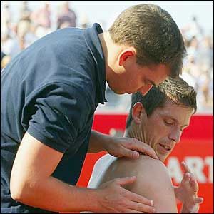 Henman is given a brief shoulder massage after the first set