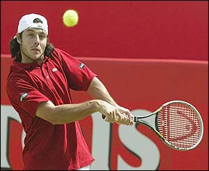 Sebastien Grosjean plays a backhand to Andy Roddick