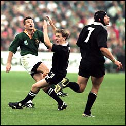 Joel Stransky kicks the winning drop goal for South Africa in the 1995 final despite the attentions of New Zealand's Andrew Mehrtens and Josh Kronfeld