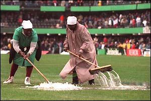 Volunteers mop up the Durban pitch after heavy rain