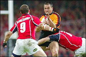 Newport's Shane Howarth is tackled by two Llanelli defenders.