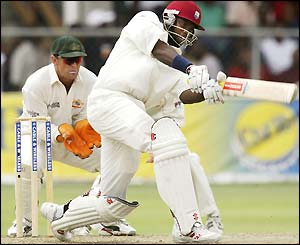 Ghris Gayle plays an off-drive in front of Adam Gilchrist