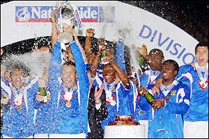 A delighted Portsmouth team lift the trophy as Division One champions