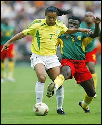 Ronaldinho wrestles the ball from Cameroon's Modeste Mbami