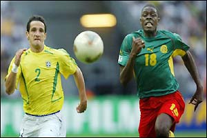 Mohamadou Idrissou (right) chases down the ball with Brazil defender Belletti 