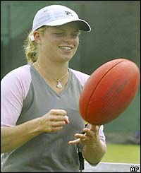 Kim Clijsters relaxes with a Aussie Rules football
