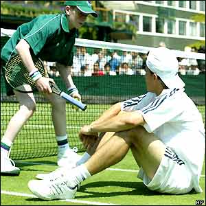 A ball boy hands a floored Guillermo Coria his racquet