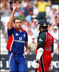 Richard Johnson celebrates taking the wicket of Zimbabwe opener Dion Ebrahim, who leaves the crease